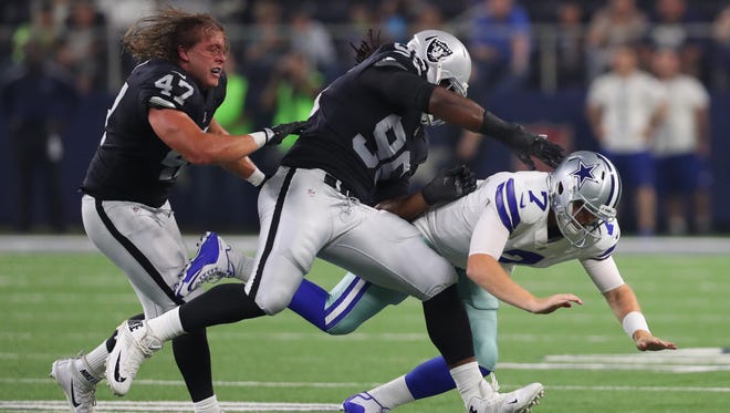 James Cowser #47 of the Oakland Raiders and Denico Autry #96 of the Oakland Raiders combine hit Cooper Rush #7 of the Dallas Cowboys after he got a pass off in the second half of a preseason game at AT&T Stadium on August 26, 2017 in Arlington, Texas.