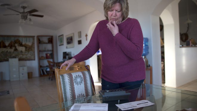 Gaydeen Graves calculates what she's  already paid to AV Water within the past five months, Wednesday, Feb. 15, 2017 at her home in the Crouch Mesa area east of Farmington.