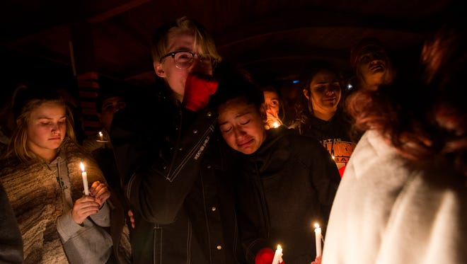 Aztec High School students Tyler Shahan, left, and Bianca Martinez react as a story is told about their classmate and friend, shooting victim Casey Jordan, by her grandparents during a candlelight vigil on Thursday at Minium Park in Aztec.