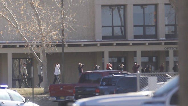 Students are led out of Aztec High School Thursday morning after a fatal shooting.