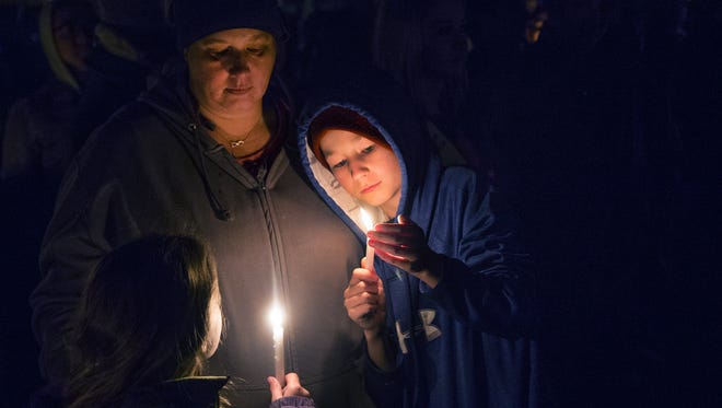 Katie Roper and her son, Tristin, 11, right, hold candles during a vigil was held at a park in Aztec, New Mexico at 6 pm, Thursday, December 7, 2017, after three people were shot to death at the local high school. Katie Roper knew one of the victims of the shooting.
