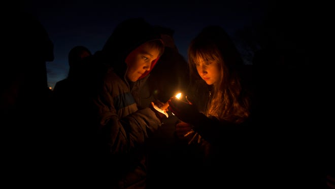 Jayden Godbay, left, and Jaci Truby participate in a candlelight vigil on Thursday, at Minium Park in Aztec.