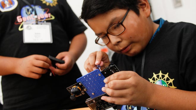 Draven Johnson assembles a control unit for his drone during Monday's session of the GenCyber Student Camp at San Juan College Quality Center For Business in Farmington.