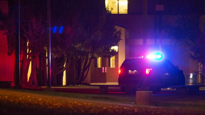 A police car sits outside Aztec High School in Aztec, New Mexico at 10 pm, Thursday, December 7, 2017, after three people were shot to death Thursday morning.