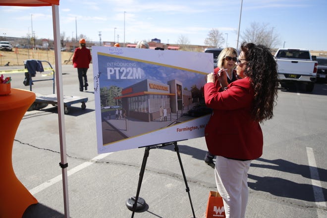 A member of the Farmington Chamber of Commerce Redcoats signs a rendering of Whataburger's planned Farmington restaurant during a Tuesday, March 12 event at the eatery's location on East Main Street.