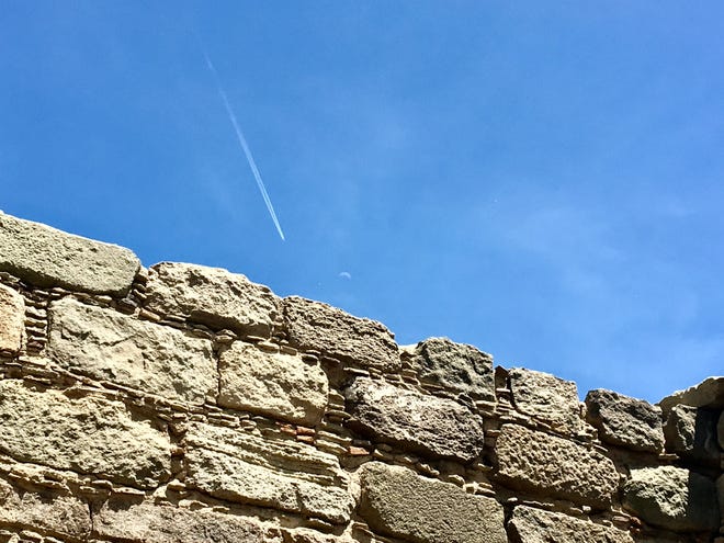 Old and new are often found in the same place in New Mexico. This wall in the Salmon Ruins complex in Bloomfield is seen in this 2017 file photo below a partial moon and a jet contrail.