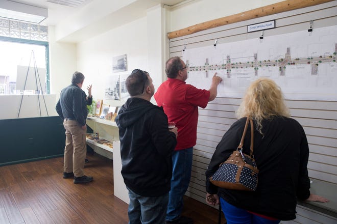 Community members and business owners look at a map of a redesigned West Main Street in downtown Farmington on April 5, 2018 at the Complete Streets headquarters.