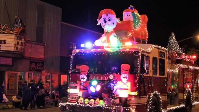 A San Juan County Fire Department truck ringed with holiday lights lit up Farmington ' s annual Christmas Parade on Dec. 5, 2019.