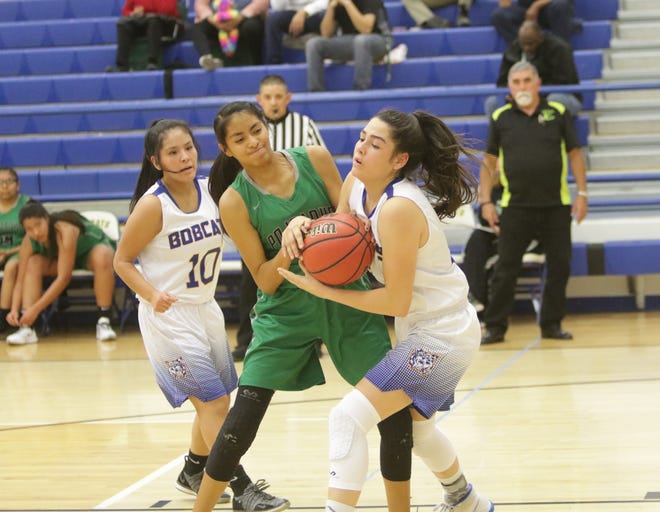 Pojoaque Valley's Amaya Gonzales and Bloomfield's Lanay Gutierrez fight for the ball during Saturday's girls basketball game at Bobcat Gym in Bloomfield.