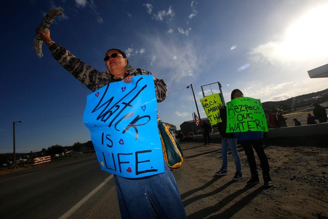 Activist Dawn Dollknife-Teller protests against AV Water Co., Friday, Sept. 23, 2016 at the intersection of County Road 390 and Highway 390 in the Crouch Mesa area.