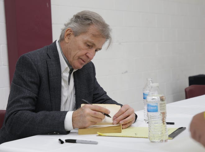 Rodney Barker signs a copy of his book "The Broken Circle" on Jan. 10, 2020, after speaking at an assembly at Rocinante High School in Farmington.