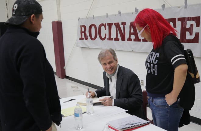 Author Rodney Barker jokes with a pair of students at Rocinante High School in Farmington on Jan. 10, 2020, while signing a copy of his book "The Broken Circle."