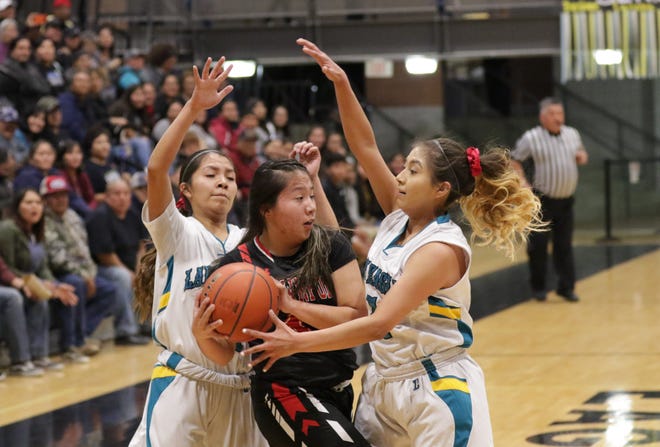 Navajo Prep's Cienna Harrison (10) and Laila Charley (1) trap Crownpoint's Amaya McMillan near the outer baseline during Wednesday's District 1-3A girls basketball tournament semifinals game at the Eagles Nest in Farmington.