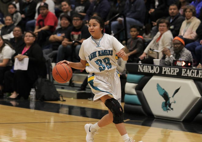 Navajo Prep's Tia Morgan dribbles the ball in transition and scans the floor for open teammates against Crownpoint during Wednesday's District 1-3A girls basketball tournament semifinals game at the Eagles Nest in Farmington.
