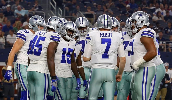 Cooper Rush #7 of the Dallas Cowboys huddles with the team during a preseason football game agaisnt the Arizona Cardinals at AT&T Stadium on August 26, 2018 in Arlington, Texas.