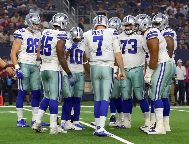 Cooper Rush #7 of the Dallas Cowboys huddles with the team during a preseason football game against the Arizona Cardinals at AT&T Stadium on August 26, 2018 in Arlington, Texas.