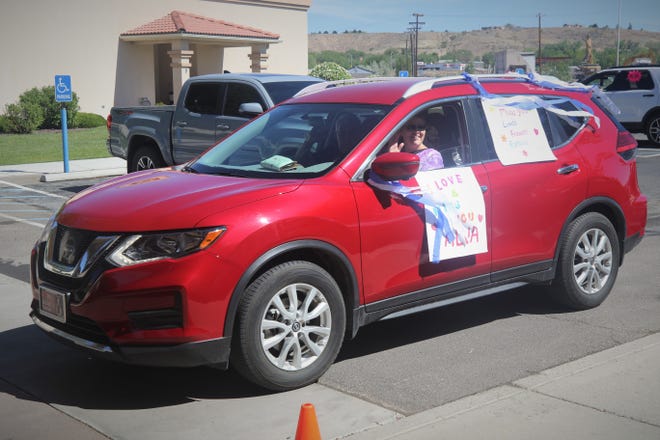 Participants in the Parking Lot Love Parade on May 13, 2020, wave to residents of The Bridge at Farmington assisted living center.