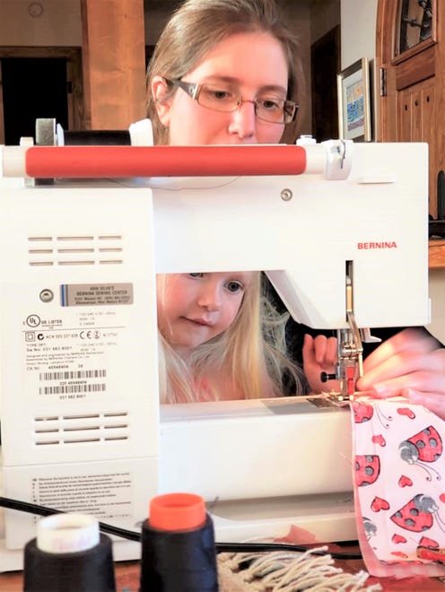 Kirby Ann Witte Taggart teaches her daughter how to sew masks for "Project Facemask." The project has made hundreds of masks since the pandemic began in March 2020.