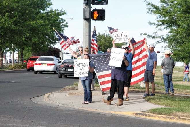 Protesters demand business restrictions be lifted, Thursday, May 14, 2020, in Farmington.