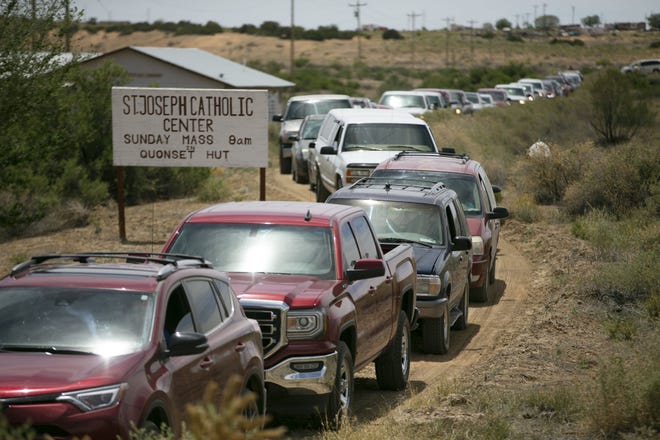 Cars line up to receive food at a food distribution point  before the start of a weekend-long curfew in Coyote Canyon, New Mexico, on the Navajo Nation on May 15, 2020.