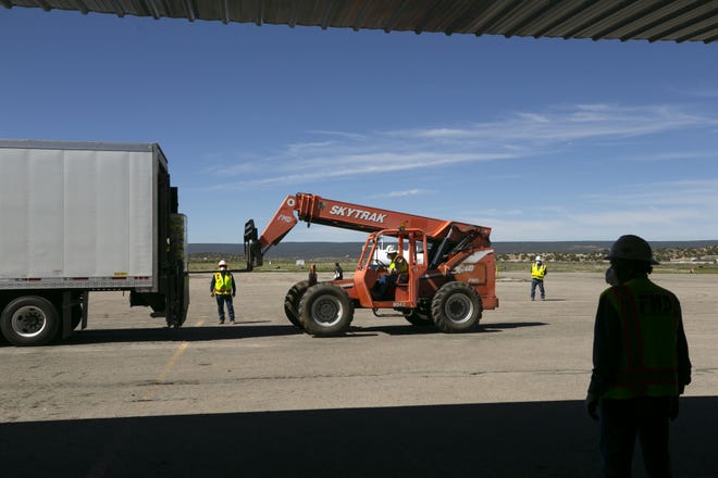 Bottled water donated from Bashas' grocery stores is removed from a truck by forklift in Window Rock on the Navajo Nation on May 15, 2020.