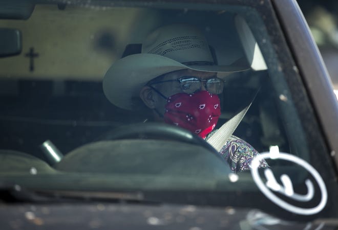 Darrell Paul waits in his vehicle to receive food before the start of a weekend-long curfew in Coyote Canyon, New Mexico, on the Navajo Nation on May 15, 2020.