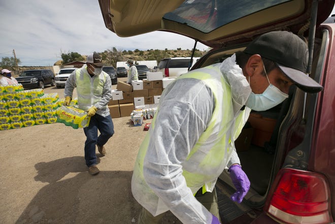 Volunteers, staff members of the Coyote Canyon chapter and the Navajo Nation Office of the President and Vice President, place fresh food, water and dog food into community members' vehicles at a food distribution point before the start of a weekend-long curfew in Coyote Canyon, New Mexico, on the Navajo Nation on May 15, 2020.