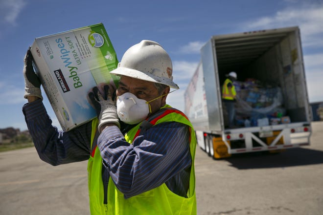 Dennison Bia, with the Navajo Nation Facilities Maintenance Department, unloads a box of baby wipes from Phoenix Indian Center to Window Rock on the Navajo Nation on May 15, 2020.