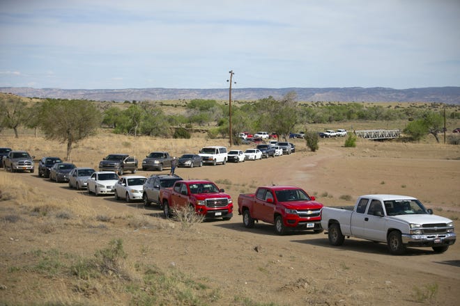 Vehicles line up to receive food before the start of a weekend-long curfew in Coyote Canyon, New Mexico, on the Navajo Nation on May 15, 2020.