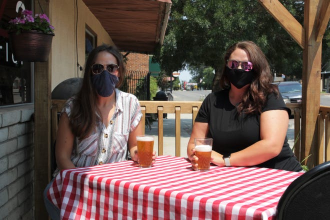 550 Brewing co-owners Micah Fiske, left, and Ericah Boyd, right, seen here on Tuesday, Aug. 18, 2020, sit in the restaurant's sidewalk patio area in front of Main Avenue in downtown Aztec.
