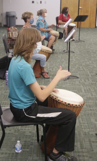 Aeon Lewis, front, Laura Ryan, Ginny Jones and Madeline Martinez pound djembes during an African drumming class at San Juan College in Farmington on Aug. 24, 2020.