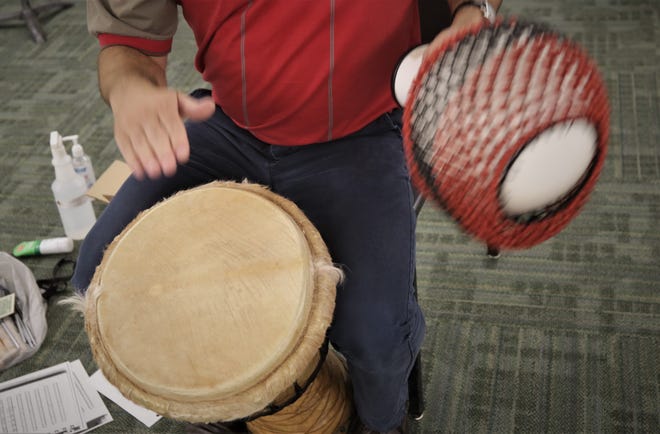 San Juan College music professor Teun Fetz pounds a djembe with his right hand while shaking a shekere with his left hand during an African drumming class on Aug. 24, 2020, on the college campus in Farmington.