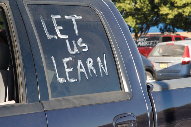 A group of Bloomfield High School students arrived at the school, Monday, Oct. 12, 2020, in a truck with "Let Us Learn" painted onto a window.