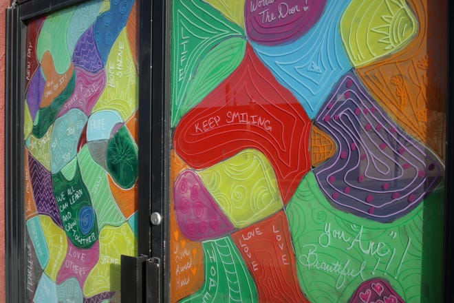 The doors to the Aztec Theater, now serving as the home of Inspire heART, are painted in bright colors and feature encouraging messages.