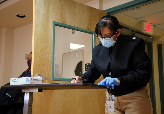 U.S. Public Health Service Commissioned Corps Lt. Cmdr. Erica Harker reviews paperwork before administering the Pfizer-BioNTech COVID-19 vaccine to Navajo Nation President Jonathan Nez on Dec. 31, 2020 at Gallup Indian Medical Center in Gallup.