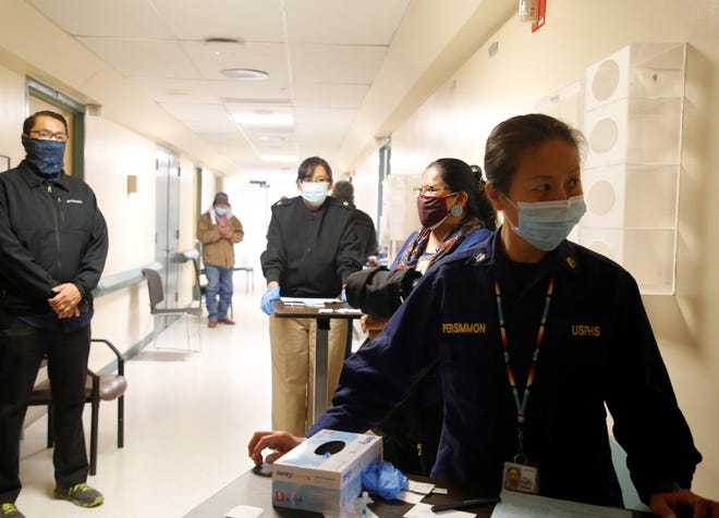 U.S. Public Health Service Commissioned Corps Cmdr. Hosun Persimmon, right, waits to administer the Pfizer-BioNTech COVID-19 vaccine to leaders from the Navajo Nation on Dec. 31, 2020 at Gallup Indian Medical Center in Gallup.