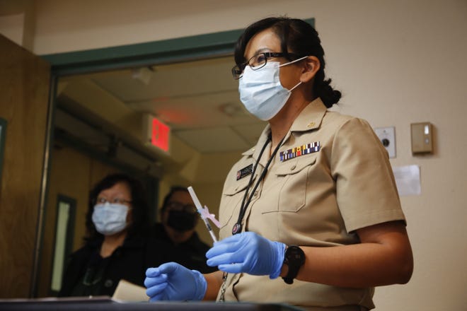 U.S. Public Health Service Commissioned Corps Lt. Cmdr. Erica Harker readies to give the Pfizer-BioNTech COVID-19 vaccine to Navajo Nation President Jonathan Nez on Dec. 31, 2020 at Gallup Indian Medical Center in Gallup.