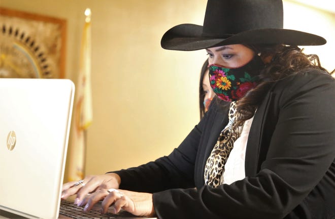 Roxanne R. Lee uses a laptop to connect to the virtual Navajo Nation chapter government inauguration on Jan. 6 at the Upper Fruitland Chapter house in Upper Fruitland. Lee was elected to serve as the chapter's grazing official.