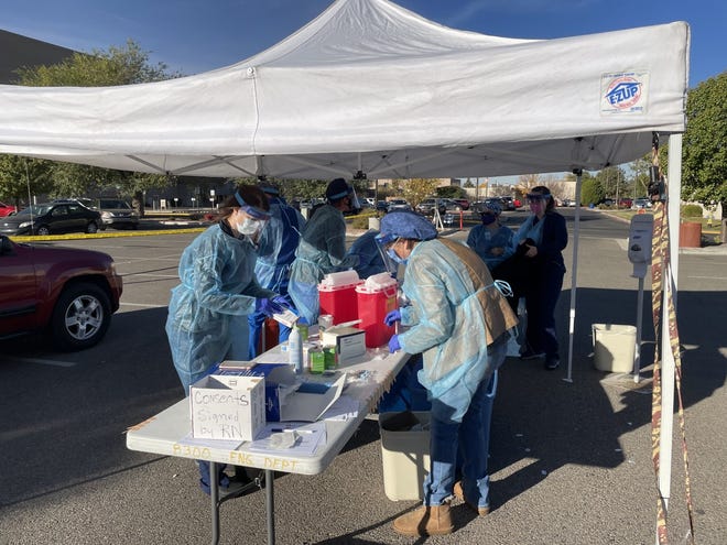 San Juan Regional Medical Center personnel prepare flu shots for local residents during one of the institution's drive-thru clinics during the fall in the hospital's parking lot.