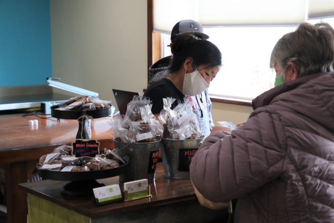 Aztec Rogue Foods co-owner Greta Quintana, center, assists a customer on Monday, March 15, 2021, in Aztec.