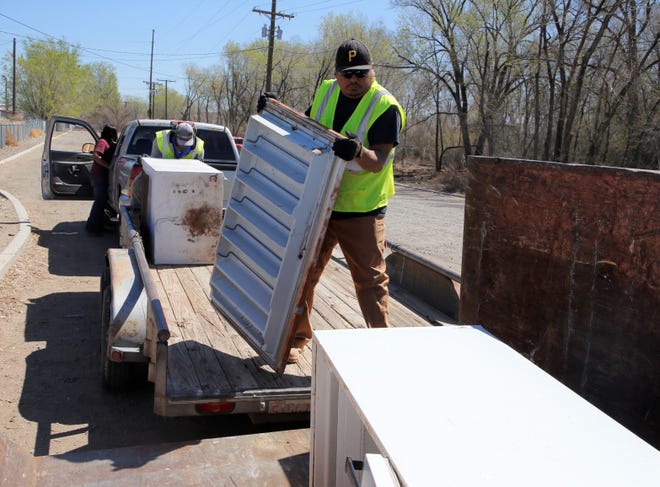 City of Farmington employees Dean Johnson, right, and Zachary Denetsone move refrigerators into a dumpster during the city's Spring Dumpster Weekend on April 10 at Berg Park in Farmington.