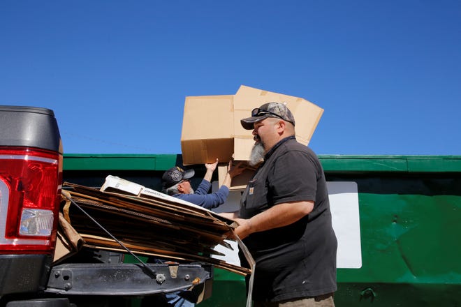 Dennis Solis unloads cardboard boxes, which his parents used to move to Farmington, at the city's Spring Dumpster Weekend on April 10 at Berg Park in Farmington.