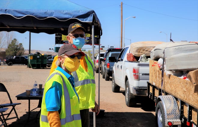 At front, Tammy Cleveland and Jimmy Miller, members of the Farmington Noonday Civitan Club, control traffic during the City of Farmington's Spring Dumpster Weekend on April 10 at Berg Park in Farmington.